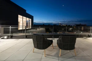 Two chairs on a rooftop during the evening, with the sun already set, casting a calm and tranquil ambiance