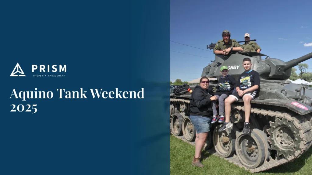 Picture of a tank with family around it. On a dark blue background, the white text "Aquino Tank Weekend 2025" is displayed below the "PRISM PROPERTY MANAGEMENT" logo.